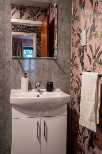 a bathroom with a white sink and a mirror at Finnieston 1BR - Walk to Hydro & SEC - Parking in Glasgow