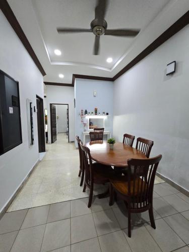 a dining room with a wooden table and chairs at PD Shell Gate Home Stay in Port Dickson