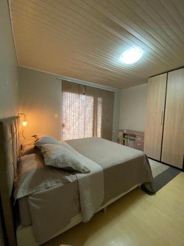 a bedroom with a large bed and a window at Quarto suíte privativa in Xaxim