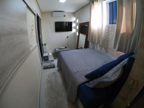 a bedroom with a bed with blue pillows at Suítes a 10 minutos de Alphaville in Barueri