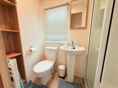 a small bathroom with a toilet and a sink at Pebbles in Selsey