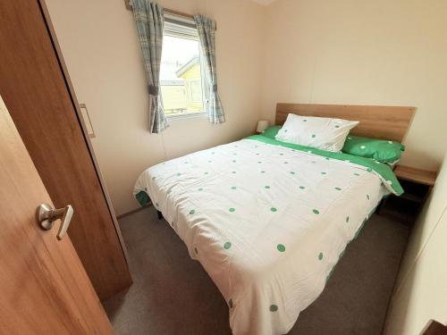 a small bed in a room with a window at Pebbles in Selsey