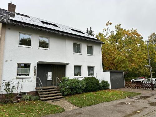 a white house with solar panels on the roof at Comfort Lodging Stueckenfeld in Hannover