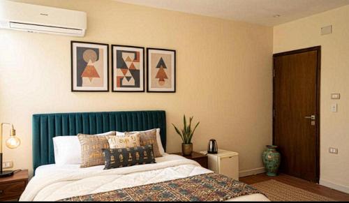 a bedroom with a bed with a green headboard at Kemet Aurora Pyramds View in Cairo