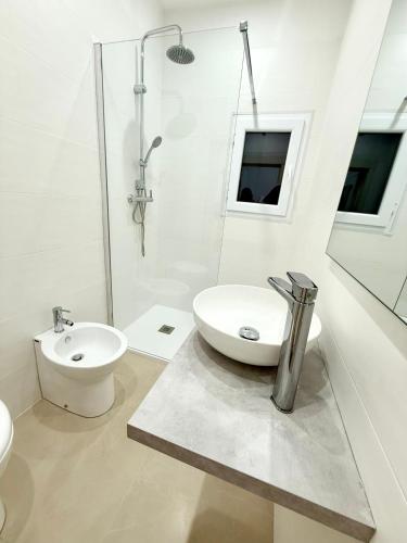 a white bathroom with a sink and a toilet at La dimora degli ulivi in Torre Santa Susanna
