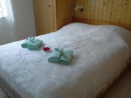 a bed with two towels and flowers on it at Berto in Nerezine