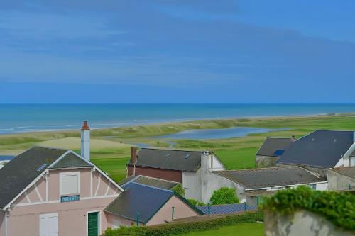 a group of houses with the ocean in the background at Le Cottage de la Baie - vue mer en Baie de Somme in Woignarue