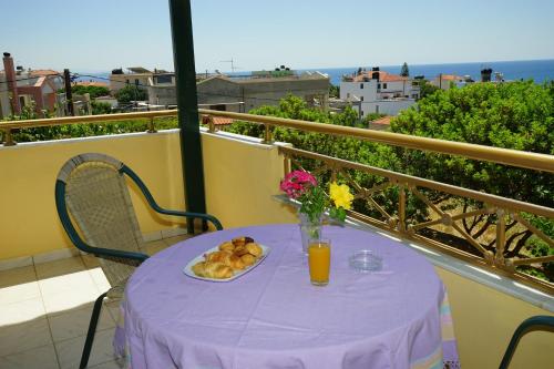 a purple table with a plate of food on a balcony at Manos in Megás Limniónas