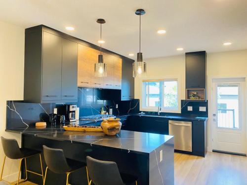 a kitchen with a large black island in the middle at NEW Luxury Family Friendly Entire House Near Downtown WEM, 3 Bedrooms in Edmonton