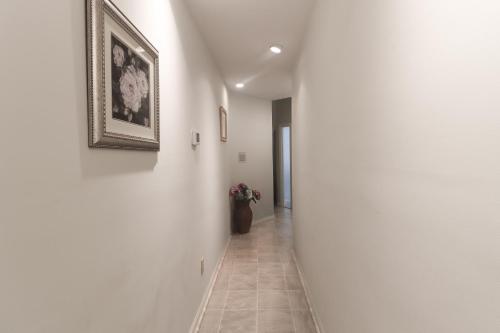 a hallway with a picture on the wall and a vase with flowers at Serene Acre Retreat- in Apex near Raleigh in Apex