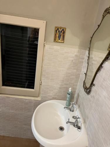 a bathroom with a white sink and a mirror at Casa Oliva Casperia, house & private olive grove in Casperia
