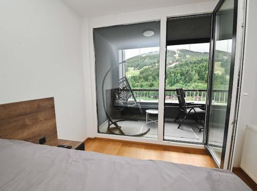 a bedroom with a bed and a balcony with a view at Bjelašnica Ski View Apartment in Bjelašnica