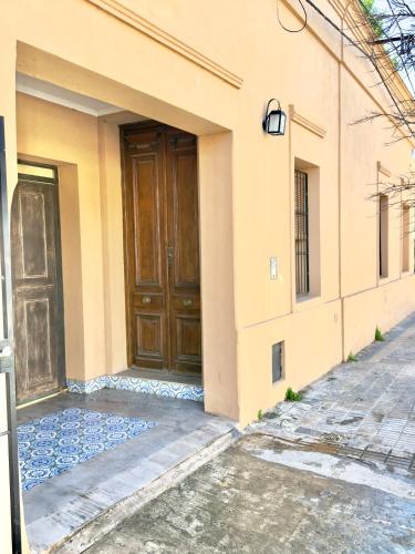 a house with a wooden door on the side of it at Lechuza Alvear in San Antonio de Areco