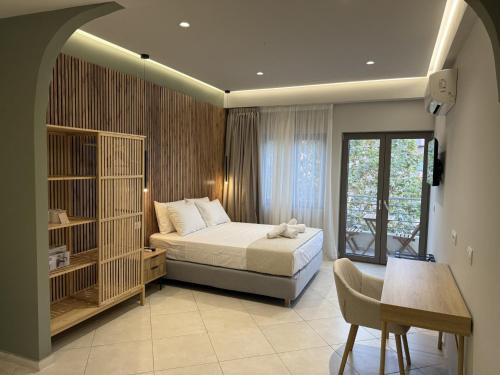 a bedroom with a bed and a table and a window at Chanioporta suites in Heraklio
