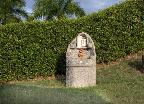 a statue of a dog sitting on top of a rock at Villa familiar con piscina y jacuzzi privado in Tocaima