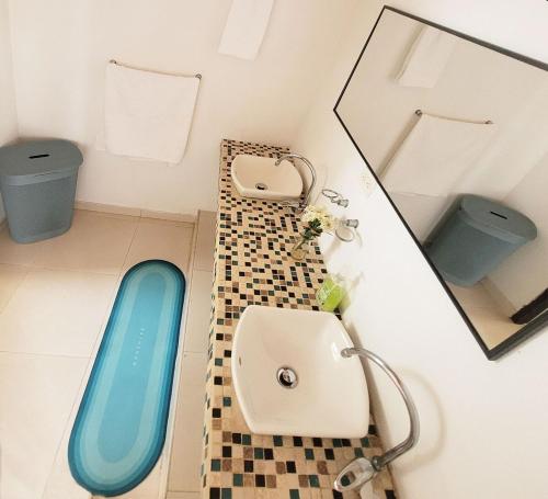 a bathroom with a blue sink and a mirror at Villa familiar con piscina y jacuzzi privado in Tocaima
