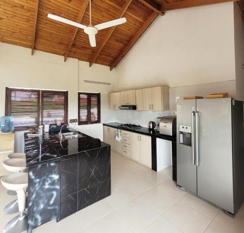 a kitchen with a black counter top and a refrigerator at Villa familiar con piscina y jacuzzi privado in Tocaima