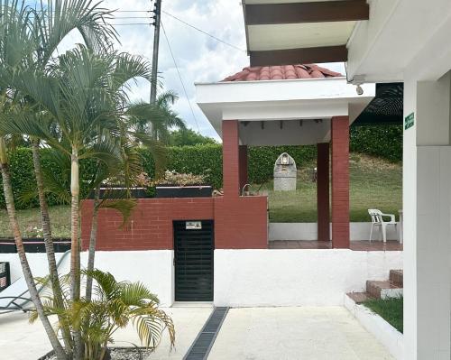 a house with a black door and a palm tree at Villa familiar con piscina y jacuzzi privado in Tocaima