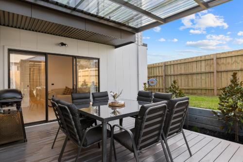 a patio with a table and chairs on a deck at San Remo Luxe 1 in San Remo