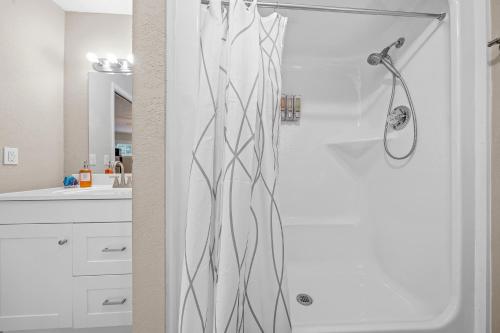 a shower with a black and white shower curtain in a bathroom at Private Poolside Guesthouse Suite! Prime Location! in Ocala