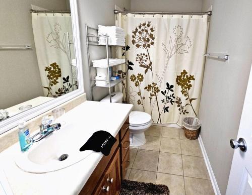 a bathroom with a sink and a toilet and a shower curtain at Lg Deck-BBQ Grill - King Suite - Near RAFB in Bonaire