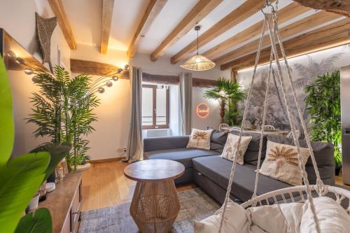 a living room with a blue couch and swing at Le Coconut 5 min du Zoo in Saint-Aignan