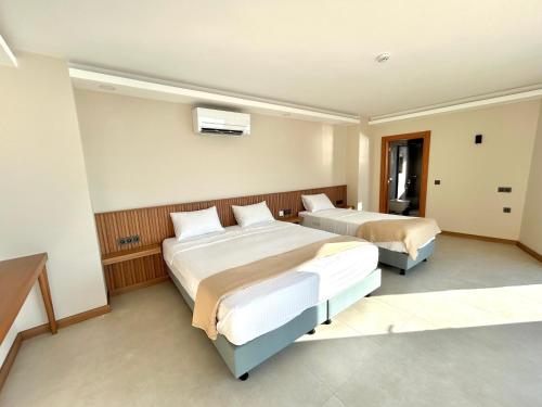 a hotel room with two beds and a window at Lyxos Hotel in Kas