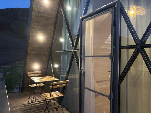 a balcony with a table and chairs and a glass door at Space Trip Hotel in Artavaz