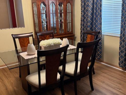 a dining room with a glass table and chairs at Magic Stay 4-Bedroom Home Close to Disney in Kissimmee