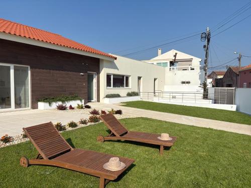 two chairs sitting on a lawn in front of a house at Casa do Rio in Aguçadoura
