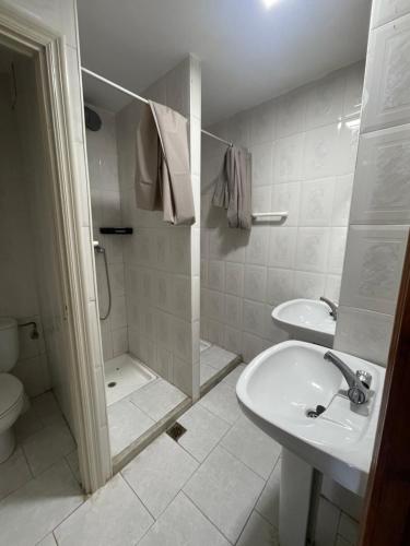 a bathroom with a sink and a shower and a toilet at Albergue de Aciera in Agüeras