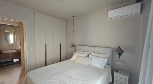 a bedroom with a white bed and a mirror at Locanda in Monemvasia