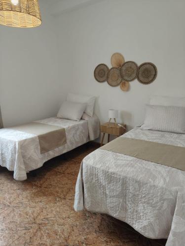 a bedroom with two beds and a mirror on the wall at Maresía La Santa in La Santa