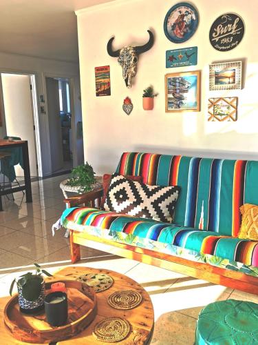 a living room with a colorful couch and a table at Blue Moon - a Bohemian retreat at Papamoa Beach in Tauranga
