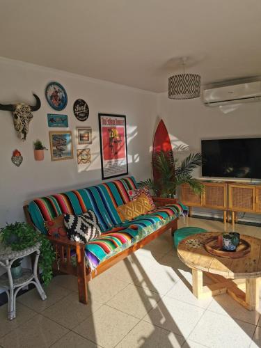 a living room with a couch and a flat screen tv at Blue Moon - a Bohemian retreat at Papamoa Beach in Tauranga