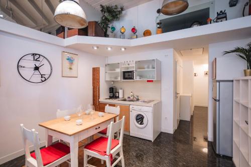 a kitchen and dining room with a table and a clock at LightBox Central in Ljubljana