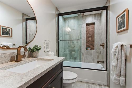 Un baño con lavabo y ducha con espejo. en Cabin Masterpiece on Private Lake 3 bedroom, en Pittsburg