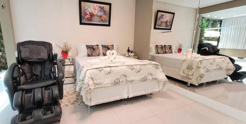 a bedroom with two beds and two chairs at Dream House in Ananindeua