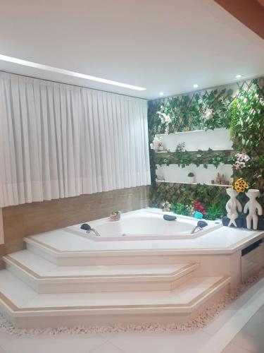 a large white bath tub in a room at Dream House in Ananindeua