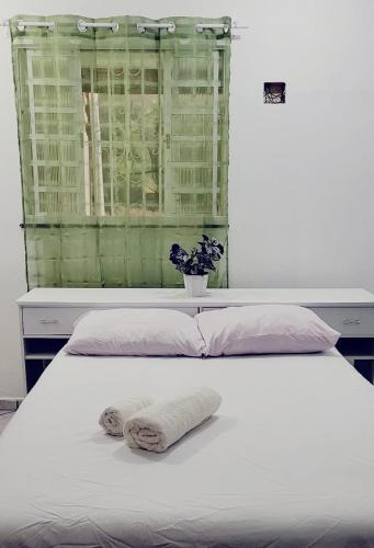 a white bed with two towels on top of it at Dream House in Ananindeua