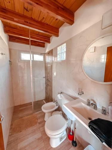 a white bathroom with a toilet and a sink at El Refugio in Córdoba