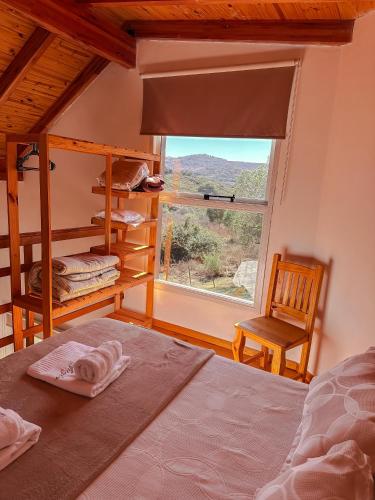 a bedroom with a bed and a window and a chair at El Refugio in Córdoba