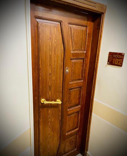 a wooden door in the corner of a room at Luxe Nest Guest House Apartment 102 in Luxor