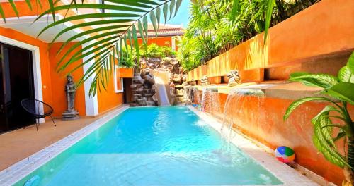 a swimming pool in a house with an orange wall at HIDELAND Luxury Pool Villa Pattaya Walking Street in Pattaya South