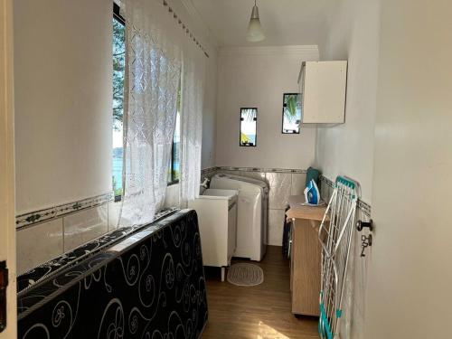 baño con 2 aseos, lavamanos y ventana en Casa com vista para o mar em Governador Celso Ramos, en Governador Celso Ramos