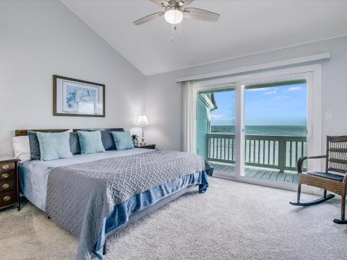 a bedroom with a bed and a view of the ocean at Bayfront Kontiki 107 in Rockport