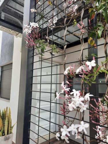 a facade of a house with flowers on it at COMPLEJO CRUZ in Alta Gracia