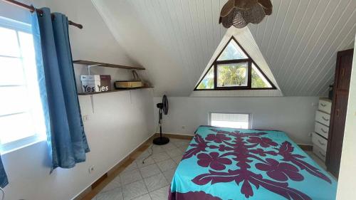 a room with a bed and a window in a attic at Villa Maraeroa PK 20,800 bord de mer in Taputapuapea
