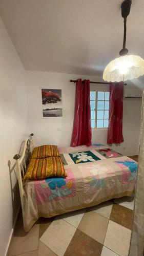 a bedroom with a bed in a room with a window at Villa Maraeroa PK 20,800 bord de mer in Taputapuapea