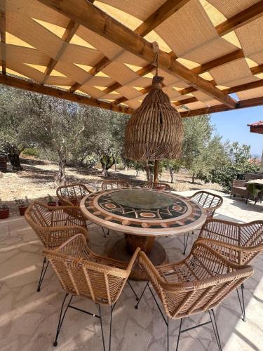 a patio with a table and chairs under a roof at Siren Village Living in Kallepia